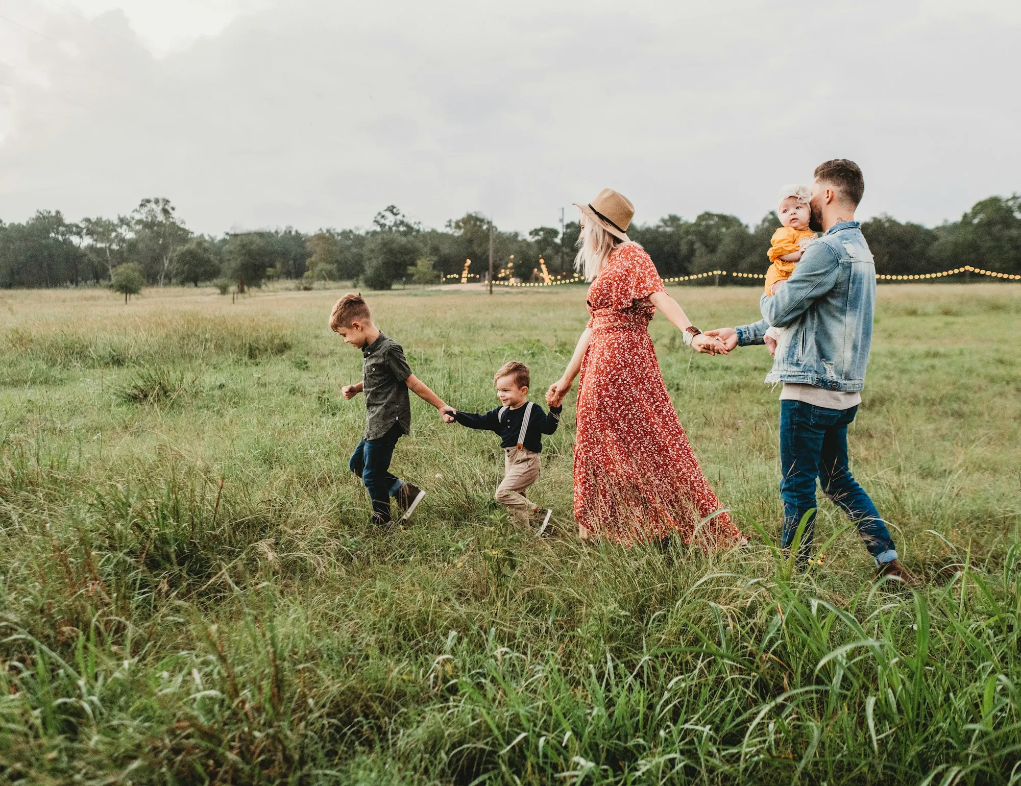 A family walking hand in hand through a grassy Texas field